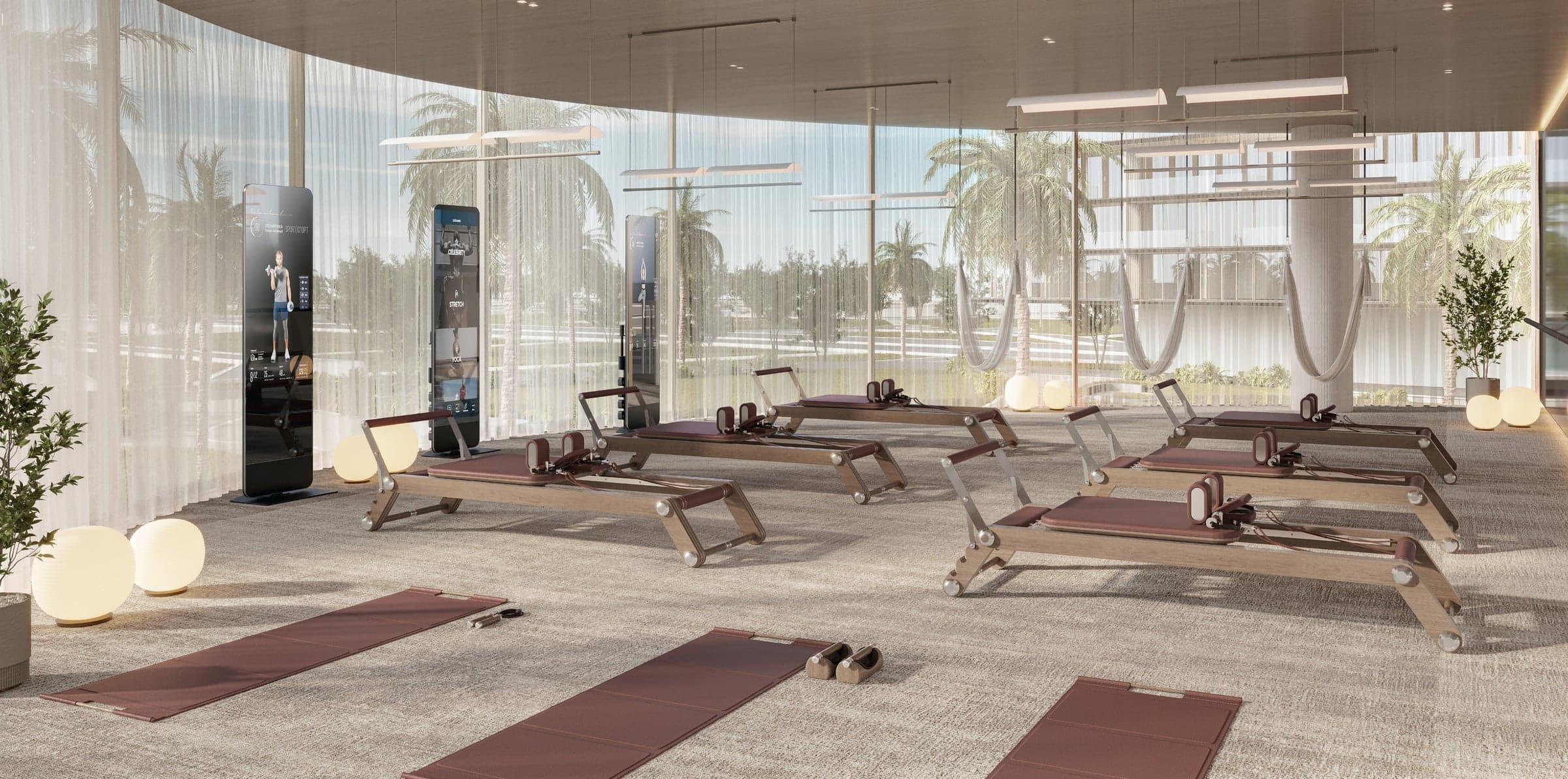 Studio za pilates sa spravama, prostirkama i ljuljaškama za jogu, uz stakleni zid prema palmama (vizuelizacija)