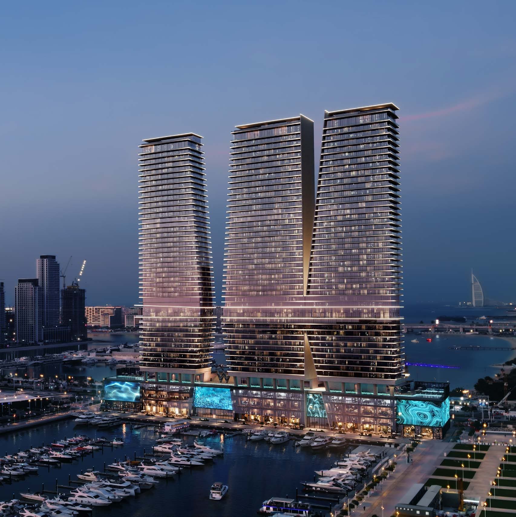 Kule W Residences iz vazduha u sumrak: podijum sa svetlećim ekranima uz marinu, desno Burj Al Arab (vizuelizacija)